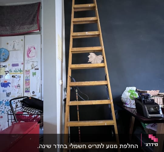 סולם עץ נשען על קיר שחור